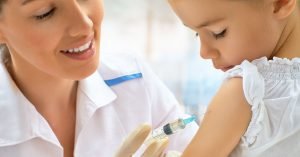 doctor examining a child in a hospital; blog: how vaccines work
