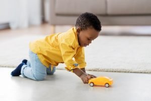 african american baby boy playing with toy car / blog - indoor activities for children