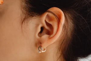 Detailed close-up of a woman's ear adorned with a stylish earring.